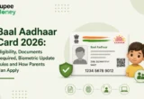 Baal Aadhaar Card 2026 illustration featuring a child, Aadhaar card, security shield, biometric verification icons, document checklist, and the RupeeMoney logo, explaining eligibility, required documents, biometric update rules, and the application process for children in India.