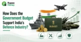 How Does the Government Budget Support India's Defence Industry infographic featuring the Union Budget, rupee coins, fighter jet, warship, tank, missile system, defence growth chart, and security shield.
