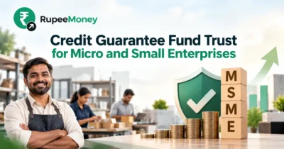 Credit Guarantee Fund Trust for Micro and Small Enterprises banner featuring an MSME business owner, protective credit guarantee shield, stacked Indian rupee coins, MSME blocks, business growth chart, and RupeeMoney branding.